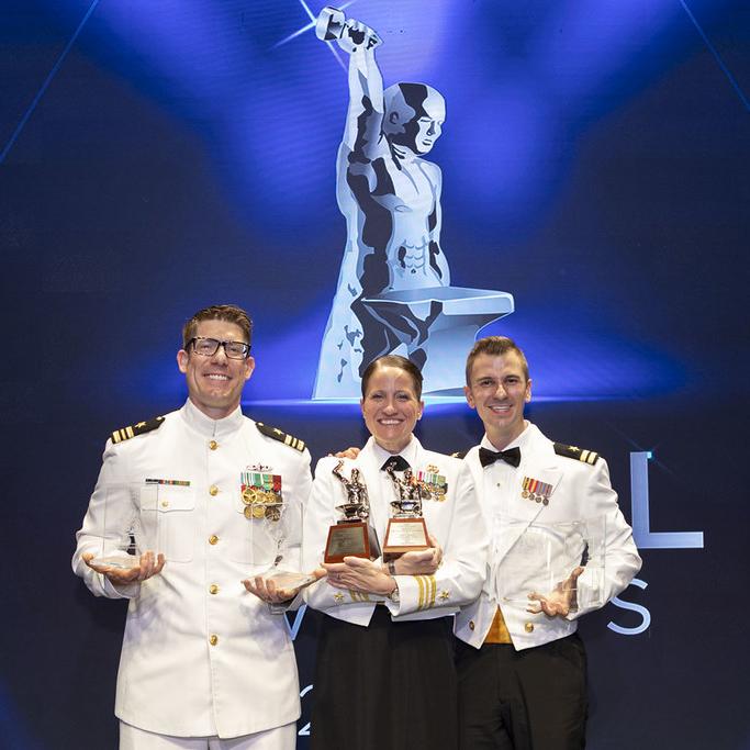 Three Anvil Award winners on stage wearing dress US Navy uniforms