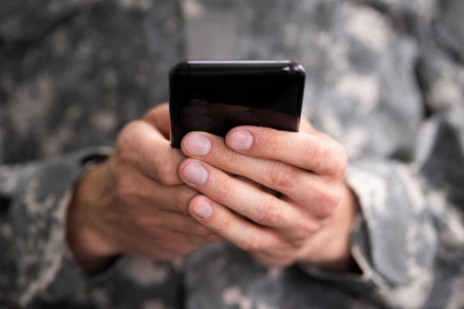 military personnel holding smartphone