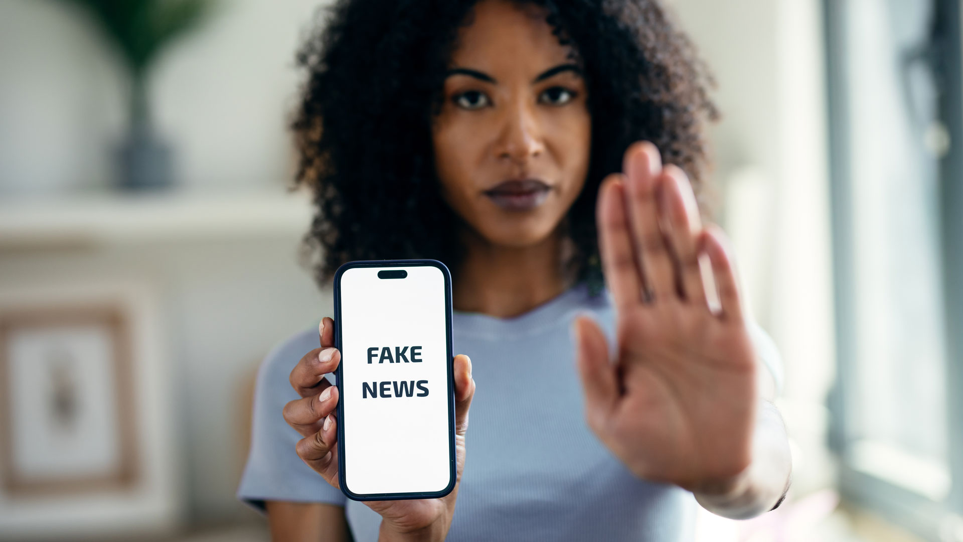 woman holding smartphone with fake news