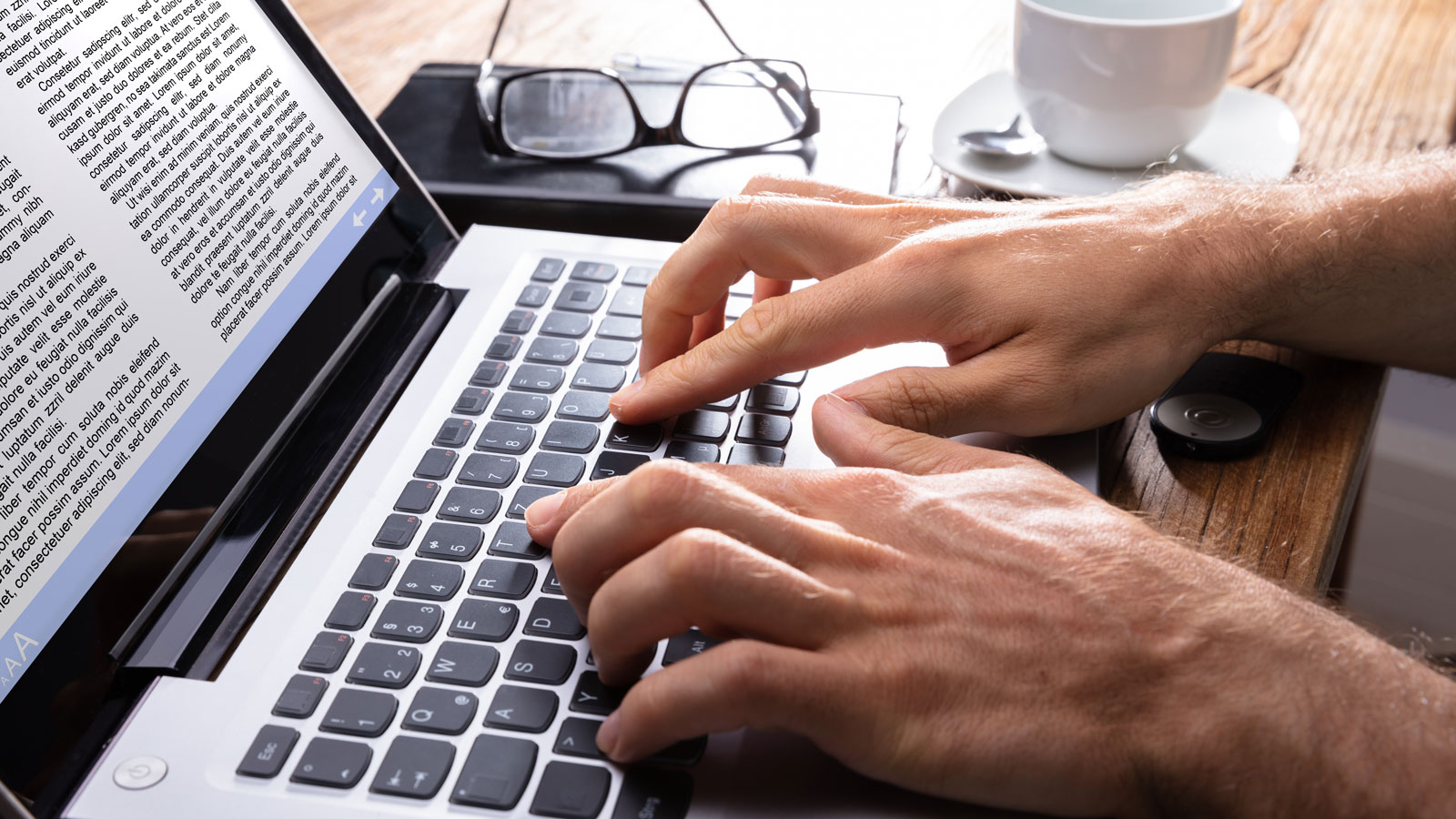 Writing fingers typing on laptop