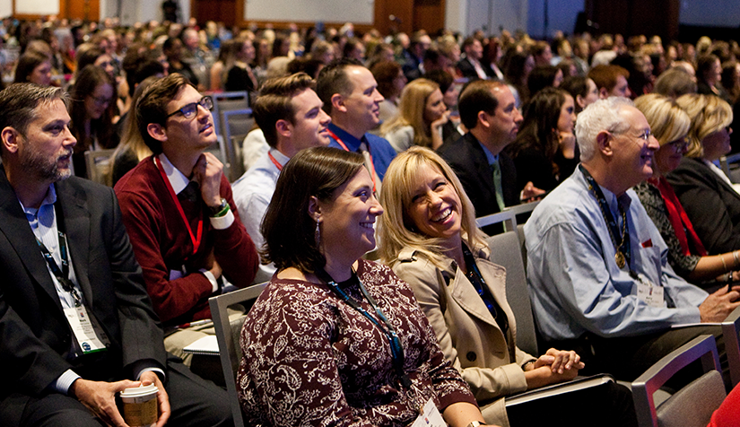 Membership Homepage Two members in an audience at a PRSA event engaged