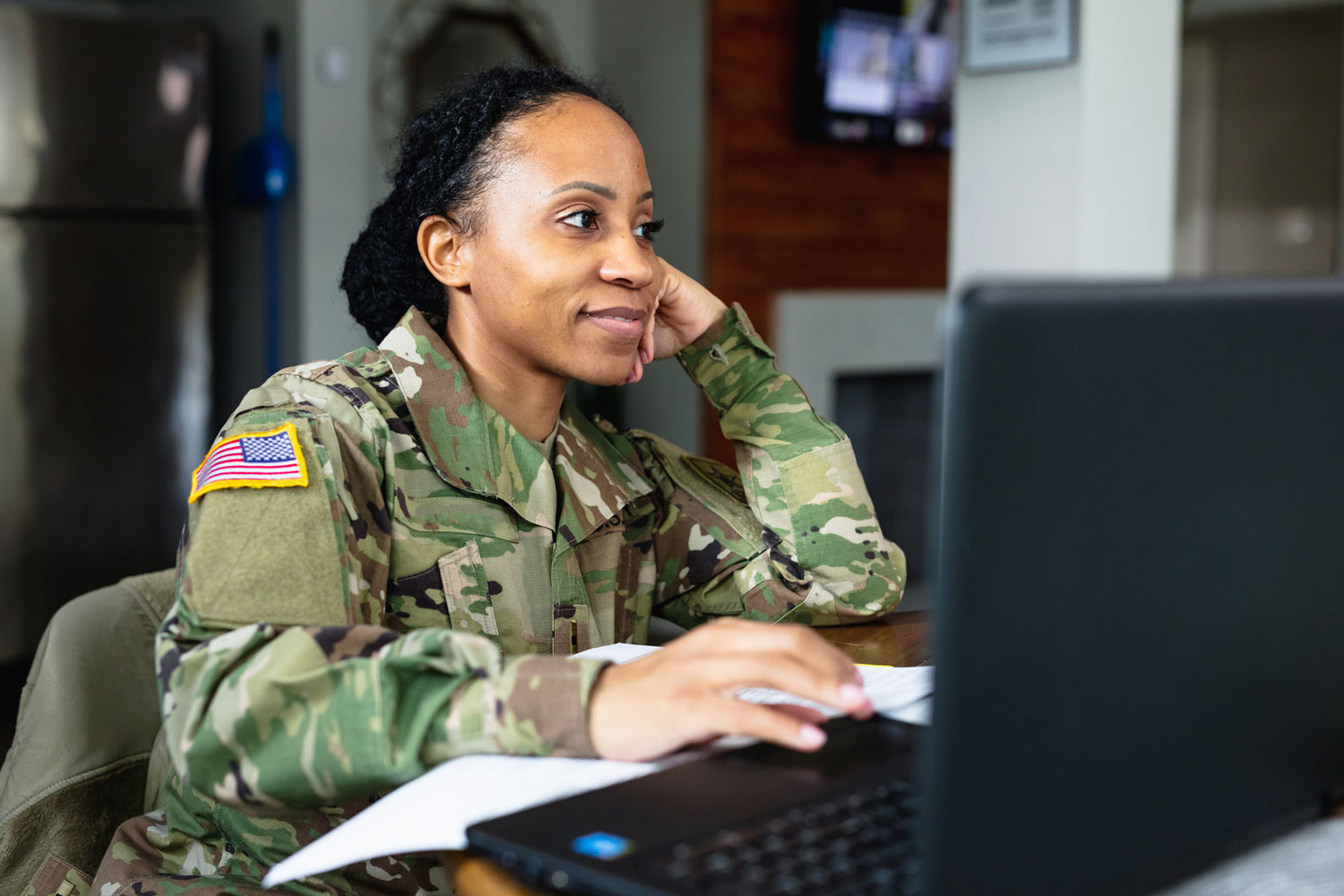 young woman in military uniform using computer