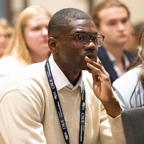 Young man in audeince with event lanyard
