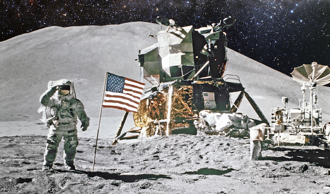 NASA footage of the moon landing. An astronaut saluting the camera with an american flag next to him.