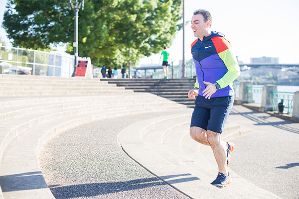 Man with a colorful sports coat running up stairs for exercise